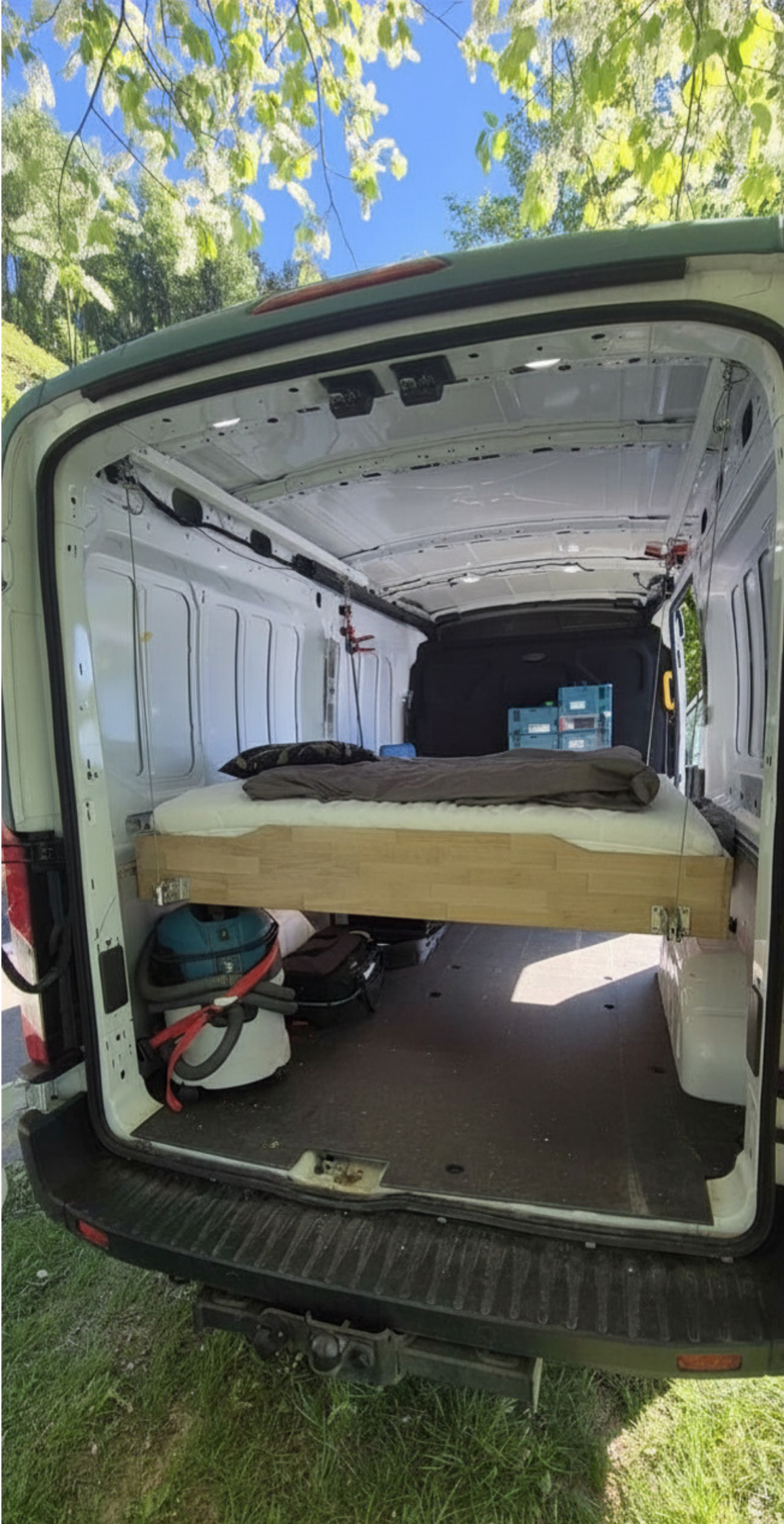 bettenHeber Hubbett im Ford Transit auf Schlafhöhe abgesenkt – mit Matratze und Bettzeug, Stauraum darunter