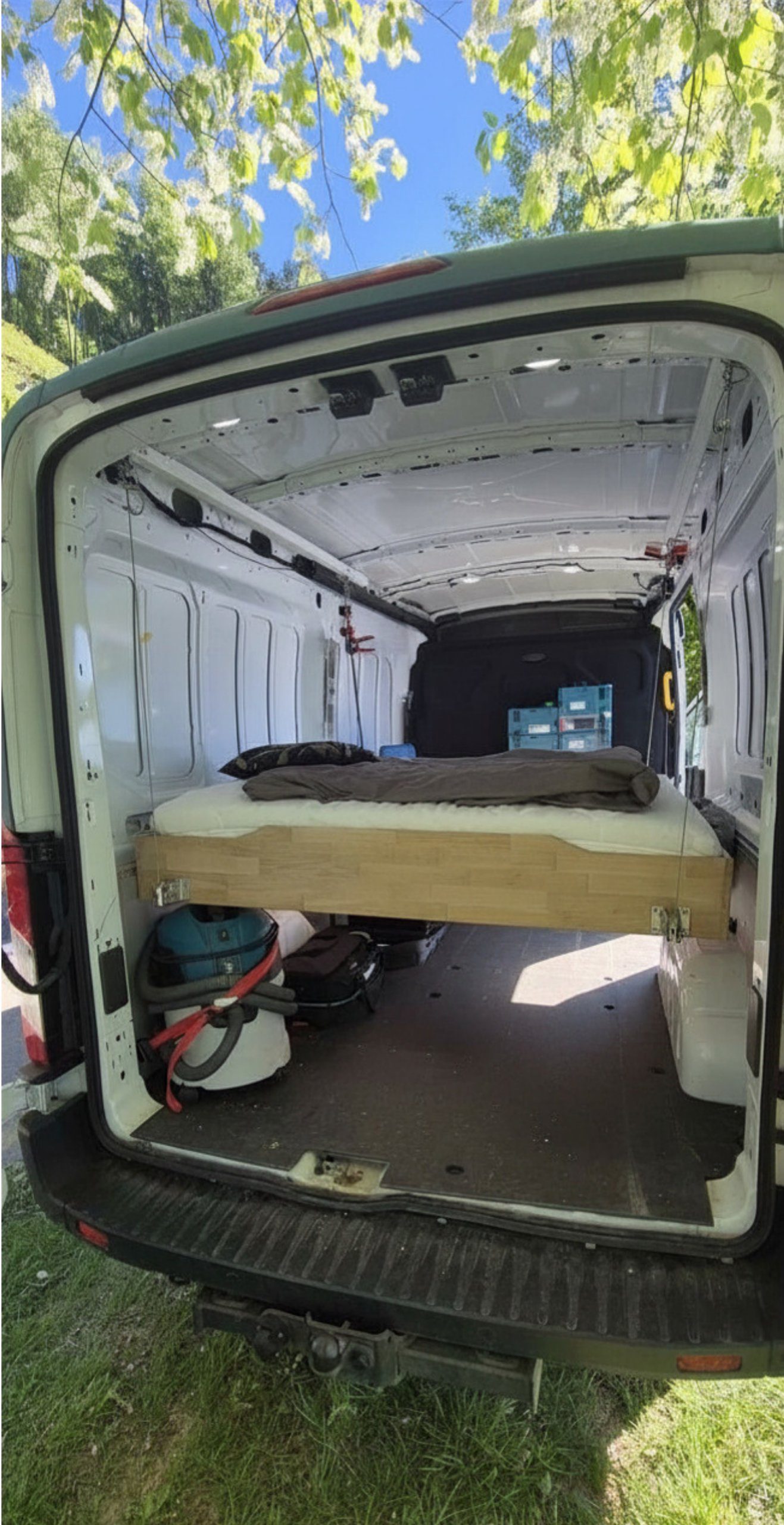 bettenHeber Hubbett im Ford Transit auf Schlafhöhe abgesenkt – mit Matratze und Bettzeug, Stauraum darunter